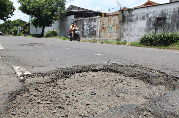 BERLUBANG: Kondisi jalan nasional di di ruas Jl Gatot Subroto tampak berlubang, Senin (5/2).