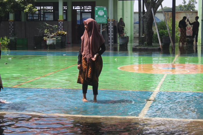 TERGANGGU: Halaman SMPN 2 Gudo banjir Jumat (2/2).