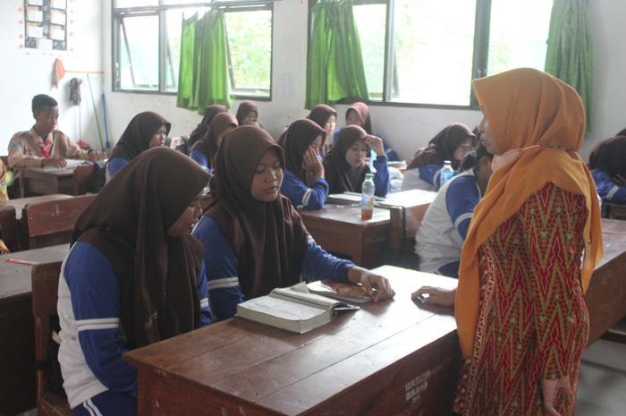SERIUS: Pembimbing mulok keagamaan saat mengajar di SMPN 1 Perak.