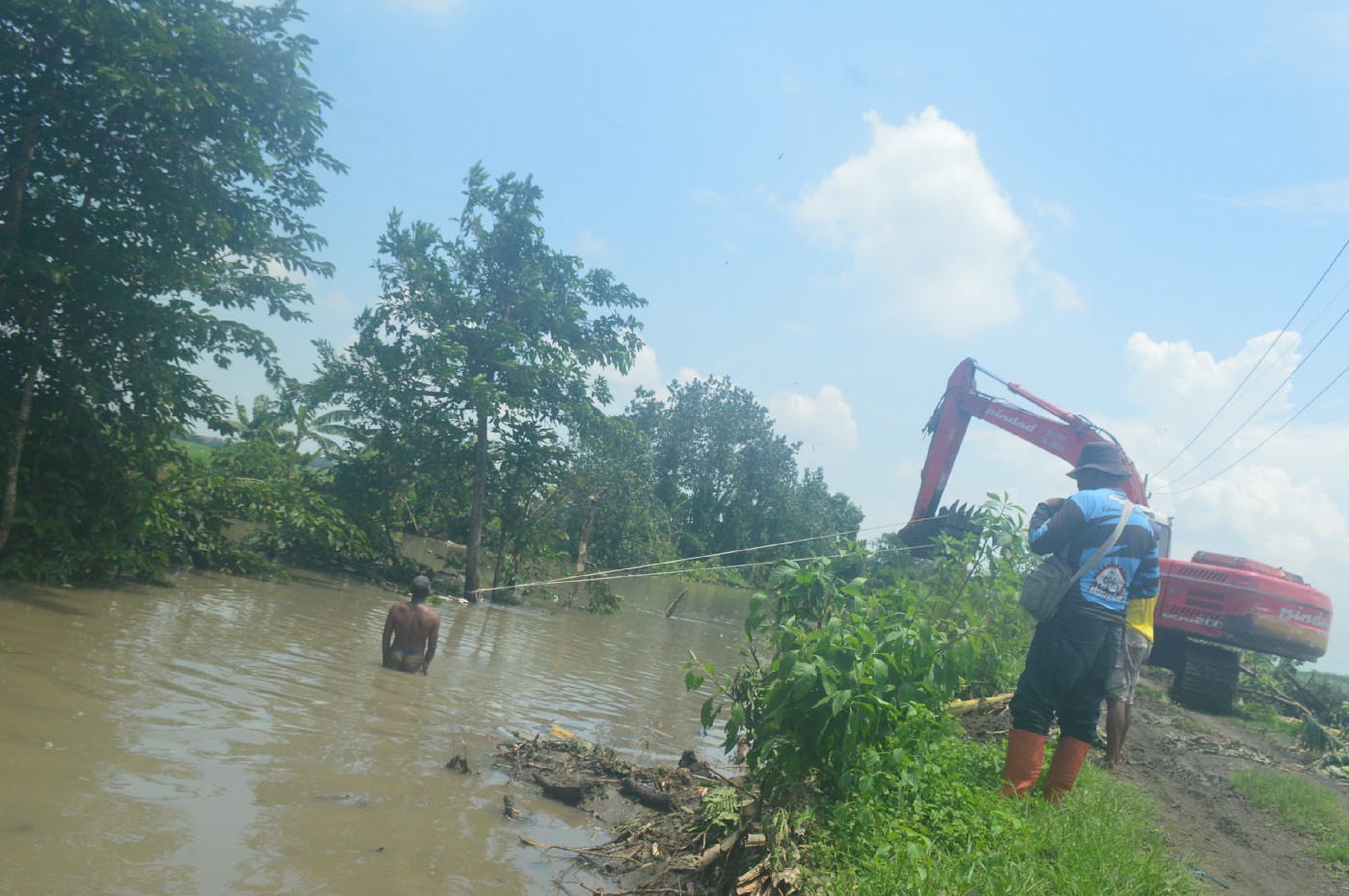DIBERSIHKAN: Pohon yang tumbuh di tengah saluran buang atau afvoer Watudakon Desa Podoroto, Kecamatan Kesamben ditebang, Rabu (31/1).