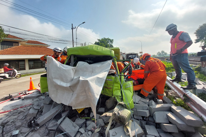 RINGSEK: Petugas mengevakuasi korban kecelakaan di jalan nasional Desa Glagahan, Kecamatan Perak, Rabu (13/2).