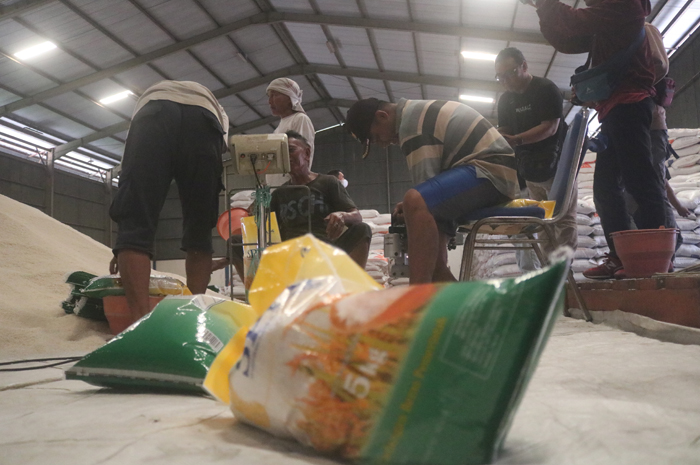 DIKEMAS: Sejumlah pekerja tengah mengemas beras SPHP di salah satu gudang Perum Bulog Mojokerto di Jombang, Rabu (21/2).