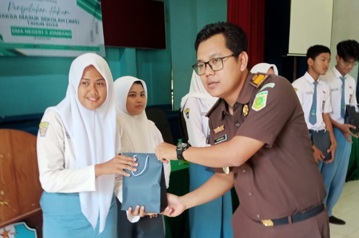 MENYENANGKAN: Penyerahan doorprize kepada siswa yang bertanya dalam penyuluhan hukum SMAN 3 Jombang, Senin (26/2).