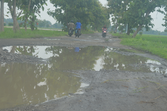 RUSAK LEBIH LAMA: Pengemudi roda dua menghindari kubangan air di Desa Gebangbunder, Kecamatan Plandaan, Jombang.