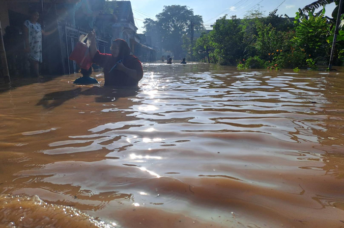 TERENDAM: Salah seorang warga Dusun Kebondalem, Desa Kademangan, Mojoagung berjalan di tengah banjir akibat luapan Sungai Catak Banteng dan Sungai Pancir, Rabu (6/3).