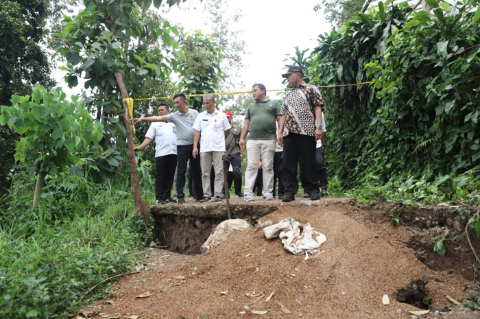 PANTAU LOKASI: Pj Bupati Jombang Sugiat bersama BPBD Jombang memantau lokasi bencana tanah gerak di Dusun Jumok, Desa Sambirejo, Kecamatan Wonosalam, Jumat (8/3) siang.