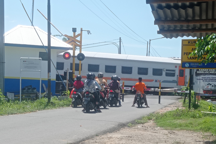 TERPASANG PATOK: Sejumlah pengguna jalan berhenti menunggu Kereta Api melintas di Dusun Gondekan, Desa Jabon, Kecamatan Jombang.