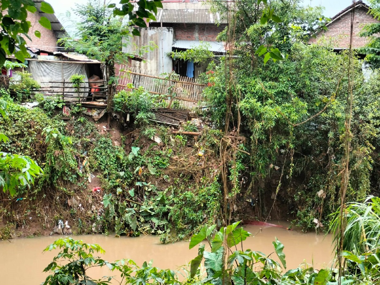 BIKIN WASWAS: Tanggul Sungai Catak Banteng di Dusun Kebondalem, Desa Karobelah, Kecamatan Mojoagung, Jombang ambrol mengancam rumah warga.