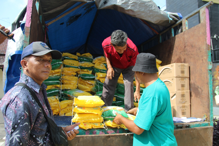 ANTRE: Sejumlah warga antre mendapatkan beras SPHP saat operasi pasar Jumat (15/3).