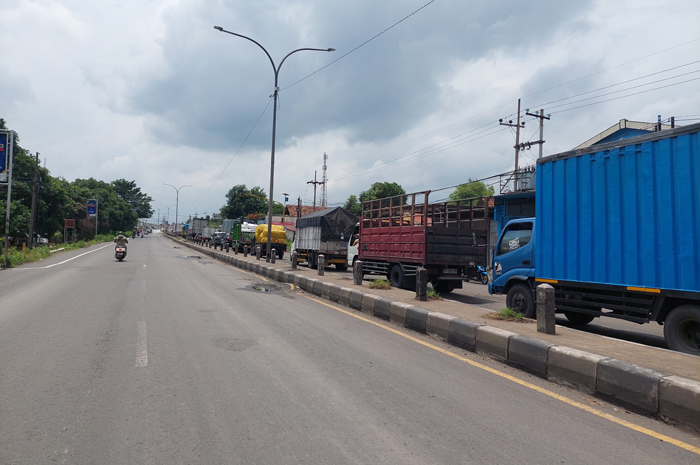 BIKIN MACET: Kendaraan mengular imbas pembongkaran cor jalan nasional di Peterongan Jombang.