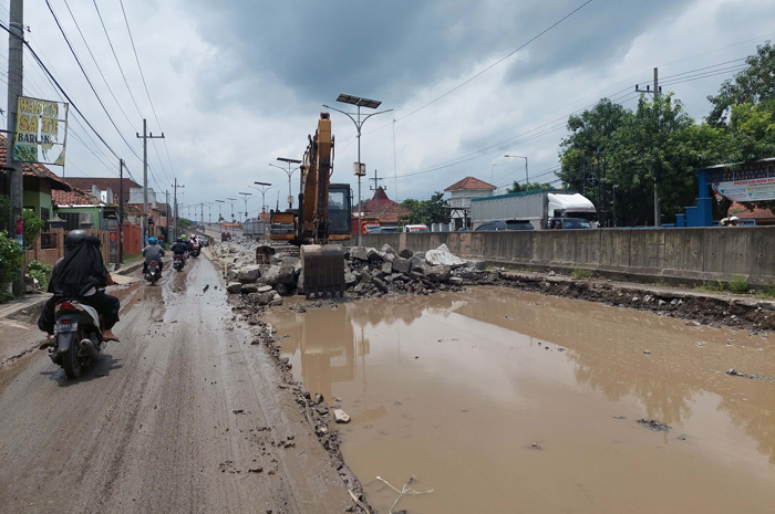 DIBONGKAR: Cor jalan nasional di Peterongan Jombang yang dibongkar mengakibatkan jalan sempit dan licin.