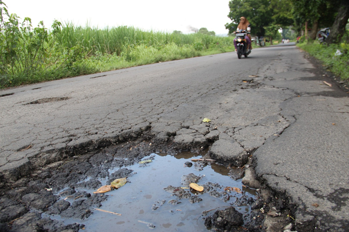 BERLUBANG: Kondisi Jl Raya Diwek penghubung Desa Diwek-Pundong tampak berlubang, Sabtu (23/3).