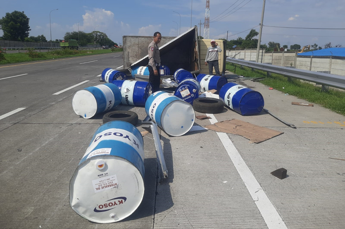 TERGULING: Truk membawa muatan 17 drum oli  mengalami kecelakaan di KM 678.200 B jalan tol Jombang-Mojokerto.