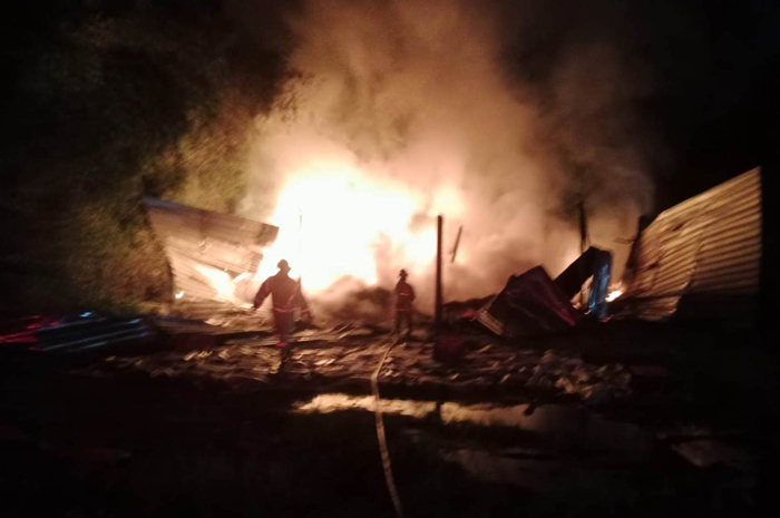 TERBAKAR HEBAT: Petugas tengah memadamkan api tempat usaha pengovenan kopra di Desa Brambang, Kecamatan Diwek, Jombang yang terbakar  Jumat (29/3/2024) petang.