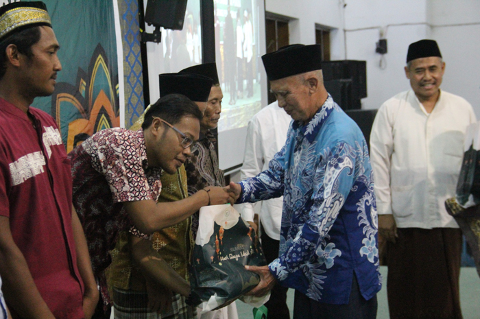 PEDULI: Pimpinan Ponpes Gadingmangu, KH Basiya Adhi Banadi, memberikan bantuan kepada warga dalam buka bersama.