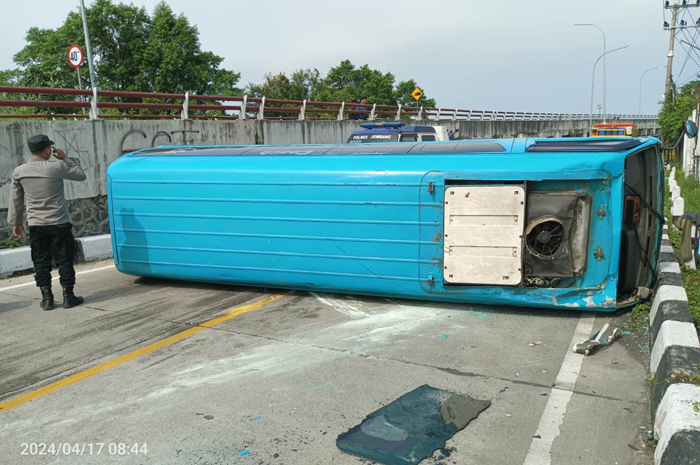 TERGULING: Mobil Isuzu Elf nopol S 7195 WB usai menabrak pembatas jalan dan menghantam pengemudi sepeda motor, di Desa Rejoagung, Kecamatan Ploso, Jombang.