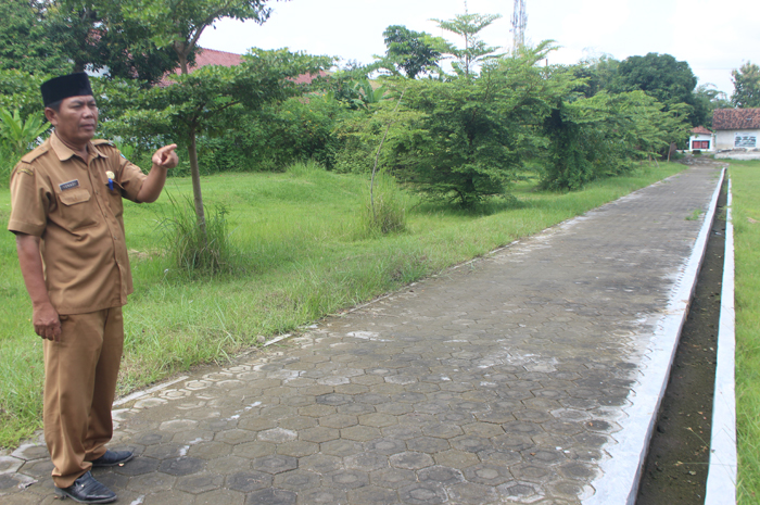 DIPERCANTIK: Kepala Desa Sukoiber Isnadi menunjukkan pemasangan paving di lapangan desa yang baru selesai dikerjakan tahun lalu.