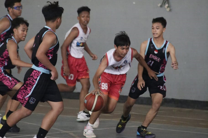 DRIBBLE: Laga final basket SMPIT Al Ummah (hitam) melawan SMPN 1 Jombang (putih) di GOR Merdeka Jombang, Minggu (28/4). Pertandingan dimenangkan SMPIT Al Ummah.