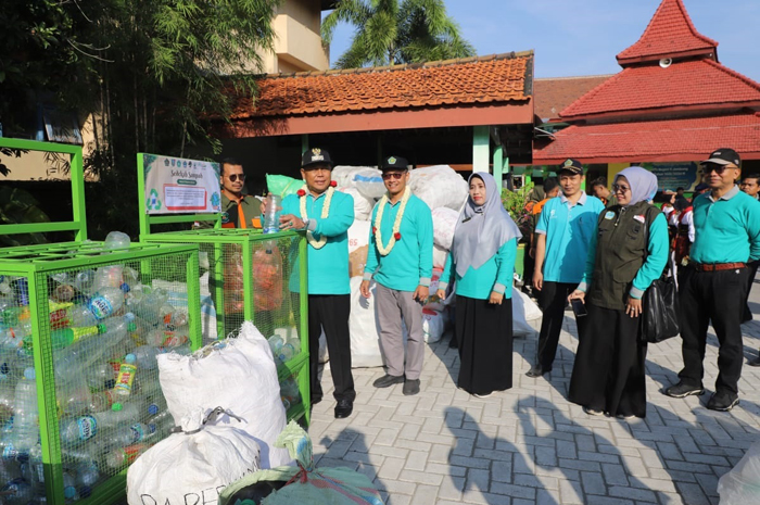 TANGANI SAMPAH: Pj Bupati Jombang Sugiat memberi apresiasi DLH Jombang dalam peringatan Hari Bumi di MTsN 11 Kecamatan Bareng, Jombang.