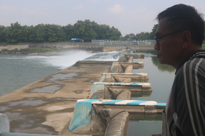 RUSAK: Salah seorang operator Dam Karet Jatimlerek di Desa Jatimlerek, Kecamatan Plandaan, Jombang, menunjukkan pintu dam yang rusak.