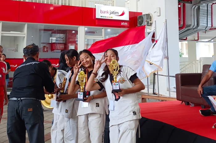 BORONG MEDALI: Tiga atlet tarung derajat usai menerima trofi penghargaan kejuaraan antar satlat di Kota Batu.