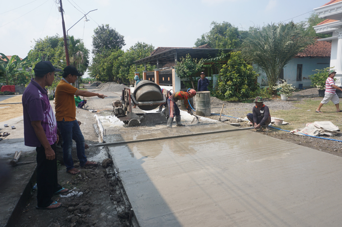 UNTUK WARGA: Kepala Desa Sentul Misbahul Arifin (tengah) menunjukkan pembangun jalan rabat beton baru di desanya.