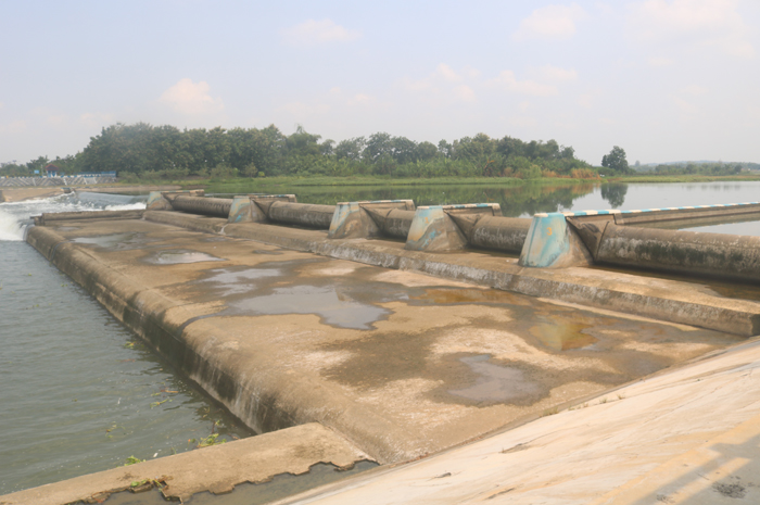 JEBOL: Air Sungai Brantas mengalir usai pintu nomor 6 (paling ujung) Dam Karet Jatimlerek berada di sisi Desa Sudimoro, Kecamatan Megaluh, Jombang jebol, penanganan estimasinya butuh waktu tiga bulan.