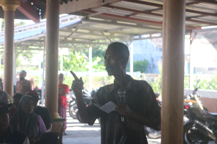 DIPROTES: Salah seorang warga Desa Karangpakis, Kecamatan Kabuh, Jombang mengeluhkan bau busuk pabrik bulu ayam saat mediasi di pendopo balai desa, Jumat (17/5).
