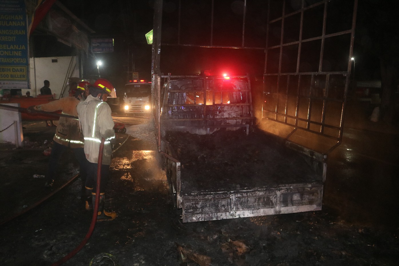 TERBAKAR: Petugas pemadam kebakaran memadamkan api pada mobil pikap yang terbakar di Desa Mojokrapak, Kecamatan Tembelang, Jombang.