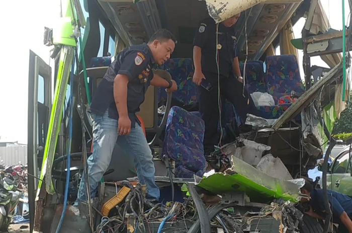 HANCUR: Petugas dari Kemenhub dan Dishub melakukan pengecekan bus yang membawa rombongan siswa SMP PGRI 1 Wonosari Malang, mengalami kecelakaan di Km 694.600 Tol Jombang-Mojokerto (Jomo).