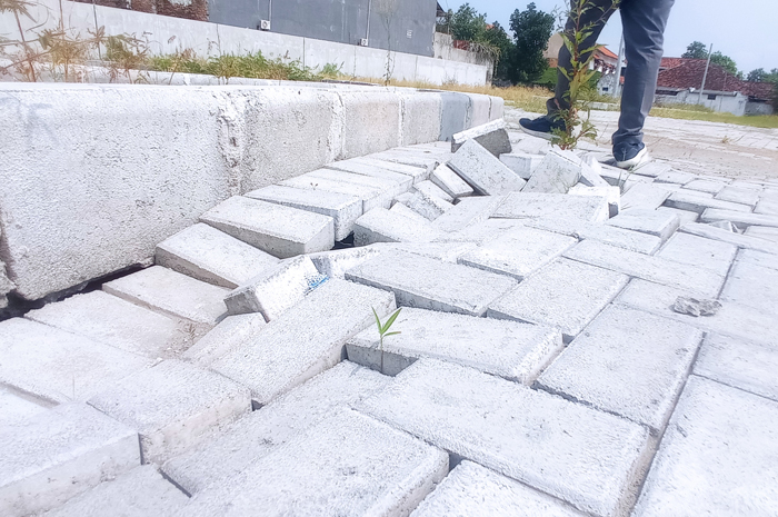 RUSAK: Kondisi paving sentra PKL jalan KH Ahmad Dahlan, Jombang yang gagal selesai ambles dan tanah uruk tergerus.