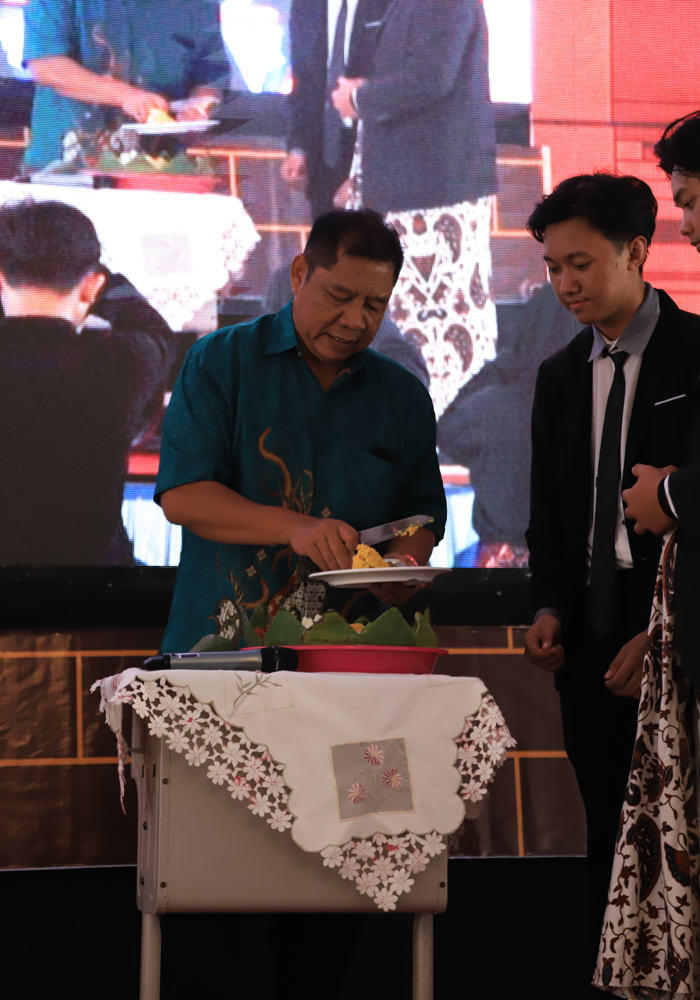 TELADAN: Kepala SMKN 1 Jombang Siswo Rusianto memotong tumpeng dalam purnawiyata siswa kelas 12.