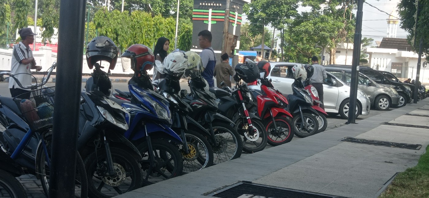 TAK DIKELOLA PEMKAB: Salah seorang pengunjung memarkir kendaraan di Alun alun Jombang yang dikelola masyarakat.