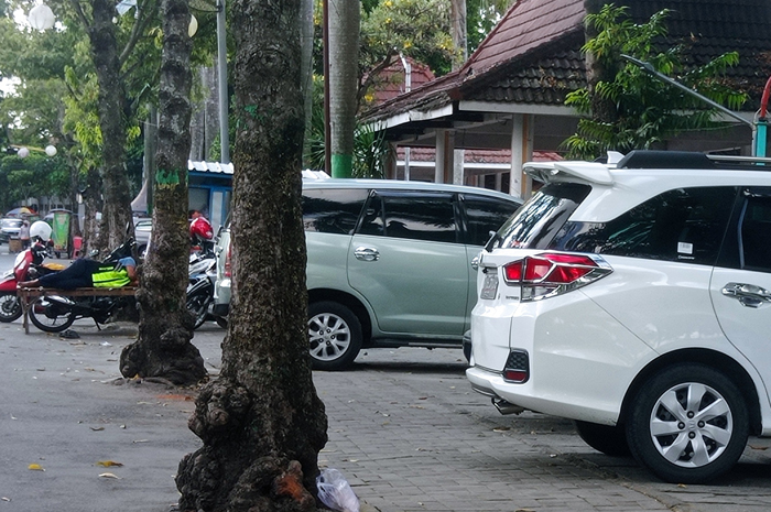 DIKELOLA MASYARAKAT: Salah seorang pengunjung Alun-Alun Jombang tengah memarkir kendaraan roda dua di sisi timur yang bakal disewakan pemkab ke kelompok masyarakat setempat.