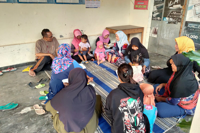 RUTIN: Kepala Desa Jombok Nugroho Adi Wiyono (kiri) memantau penimbangan berat badan balita stunting.