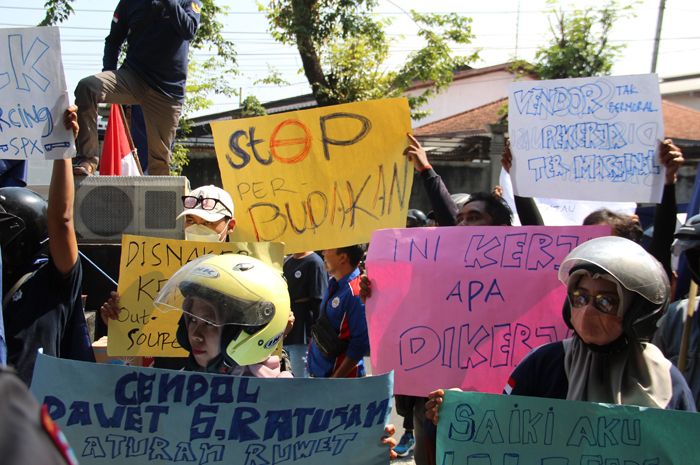 SAMPAIKAN TUNTUTAN: Ratusan buruh dari berbagai perusahaan, menggelar aksi demo di perusahaan jasa pengiriman barang Jl Prof Nur Cholis Majid, Tunggorono, Jombang, Rabu (5/6) siang.