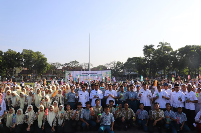 RAMAH LINGKUNGAN: Pj Bupati Jombang Sugiat bersama pelajar menunjukan tumbler dalam peringatan hari lingkungan hidup sedunia.