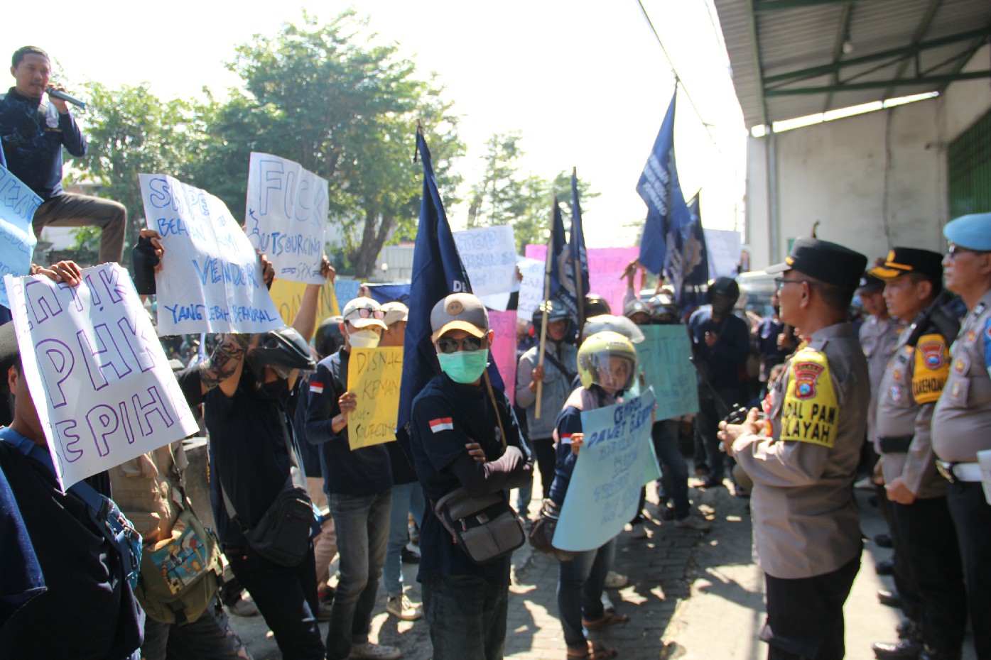 SAMPAIKAN TUNTUTAN: Ratusan buruh saat menggelar aksi demo di salah satu perusahan cabang jasa pengiriman di Jl Prof Nur Cholis Majid, Jombang, Rabu (5/6) siang.