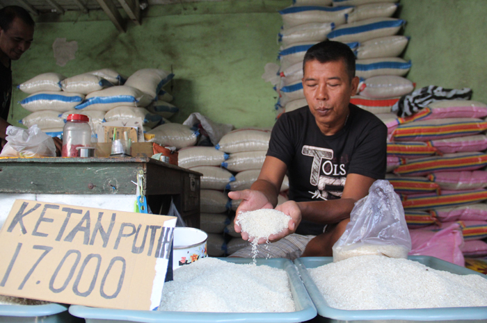 STOK AMAN: Sugandi, salah satu pedagang beras di Pasar Citra Niaga Jombang menunjukan beras jenis bramu.