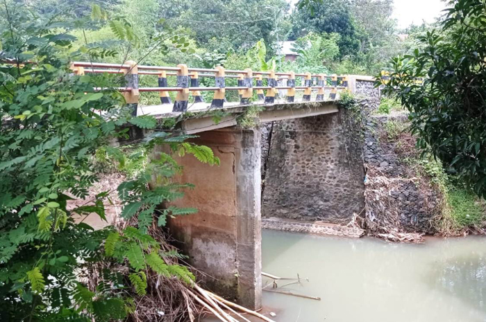 BAKAL DITANGANI: Warga melintas di jembatan Dusun Banjaragung, Desa/Kecamatan Bareng, Jombang terdampak banjir bandang akan diperbaiki pemerintah pusat (29/3).