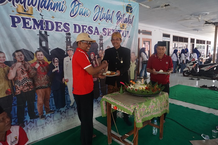POTONG TUMPENG: Kepala Desa Sentul Misbahul Arifin menyerahkan potongan tumpeng kepada Ketua BPD Desa Sentul dan Ketua panitia sedekah desa.