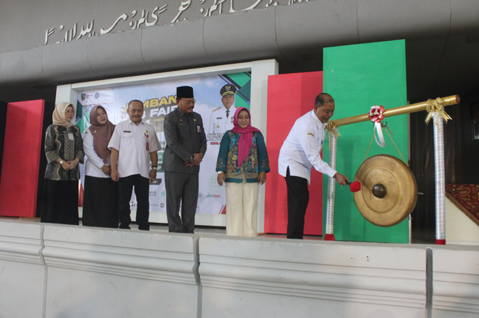 TELADAN: Pj Bupati Sugiat memukul gong membuka job fair yang digelar Disnaker Jombang di Auditorium Undar, Rabu (26/6).