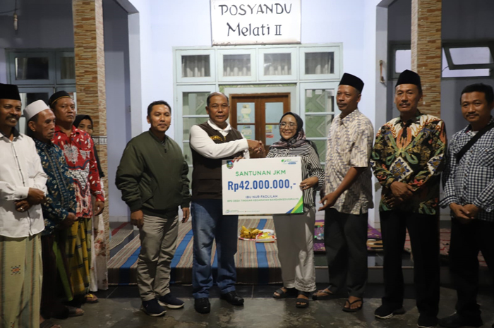 PEDULI: Kepala BPJS Ketenagakerjaan Cabang Jombang, Nurhadi Wijayanto, mendampingi Pj Bupati Sugiat memberikan santunan kematian kepada ahli waris di Desa Tinggar Bandarkedungmulyo, Jumat (28/6).