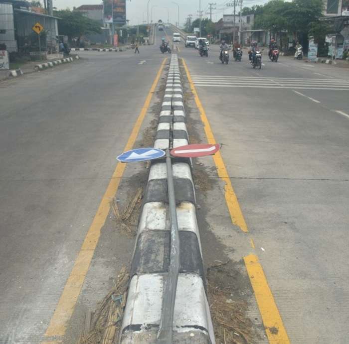 TERGELETAK: Rambu lalu lintas di jalan provinsi menuju jembatan baru Ploso di Desa Bedahlawak, Kecamatan Tembelang, Jombang dibiarkan ambruk (3/7).