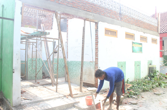 TANPA PAPAN NAMA: Pekerjaan rehab toilet sedang dilaksanakan di SMPN 3 Jombang, Senin (8/7).