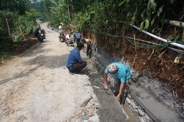 KOKOH: Kepala Desa Galengdowo Wartomo (kemeja biru) menunjukkan lokasi pembangunan drainase di Dusun Galengdowo yang sedang dikerjakan oleh TPK Desa Galengdowo, Wonosalam, Jombang.