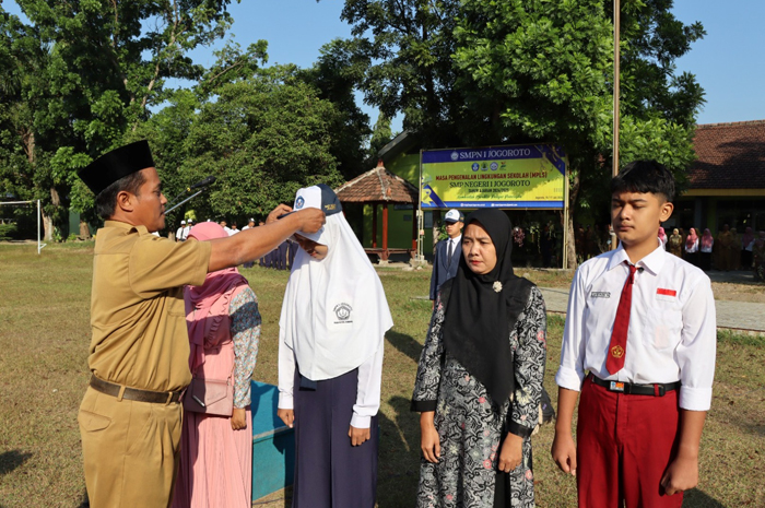 DISIPLIN: Kepala SMPN 1 Jogoroto, Jombang, Muhamad Khoiri SPd, menyerahkan id card tanda peserta secara simbolis.