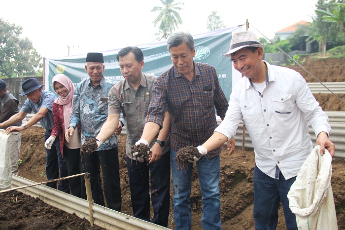PELUANG BISNIS: Direktur Jawa Pos Radar Jombang M. Nur Kholis dampingi Ali Murtadhlo Ketua Koperasi Syariah Sabiilus Salam Sejahtera saat penebaran cacing, di area Villa Firly Salam Wonosalam, Jombang