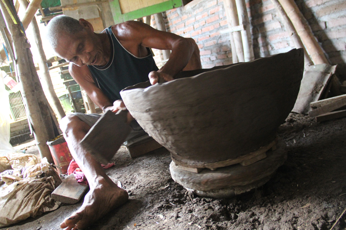 KREATIF: Tiamun, 75 warga Dusun Sanan timur Desa Mojotrisno, Mojoagung, Jombang, saat membuat gentong Mojopahit di rumahnya,