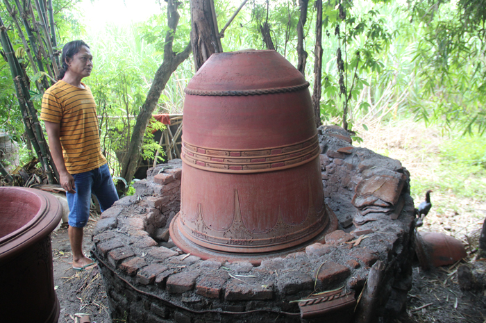 KREATIF: Buah karya Tiamun, 75 warga Dusun Sanan timur Desa Mojotrisno, Mojoagung, Jombang membuat gentong Mojopahitan di rumahnya.